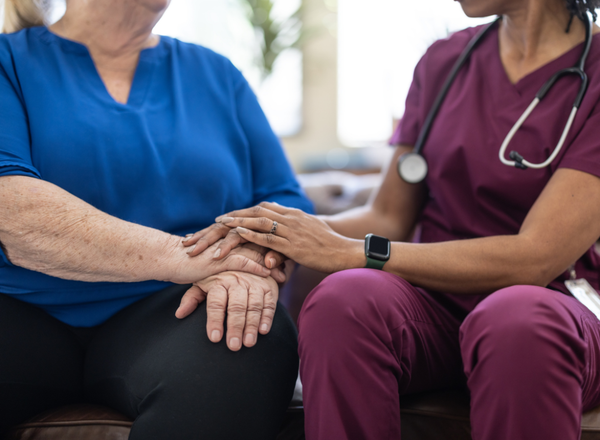 A doctor holding a patients hands