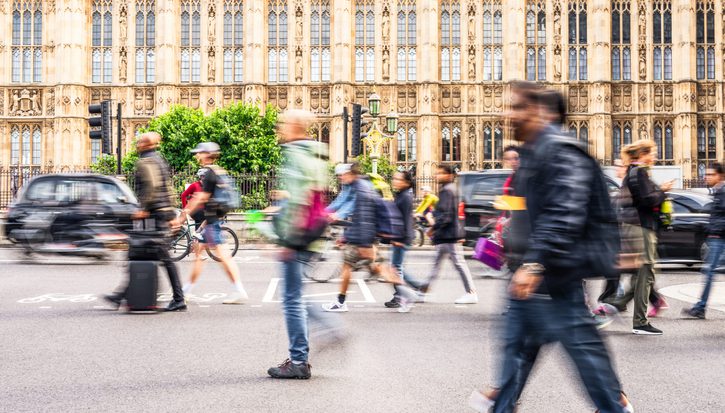 London, a busy street outside the houses of parliament, with blurred people walking in front of the grand building