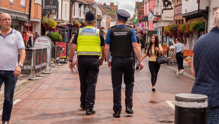 A photo of police officer and a community support officer walking down a quiet street in Kent