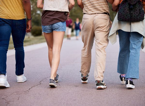 Rear view of unrecognizable people walking together on the street