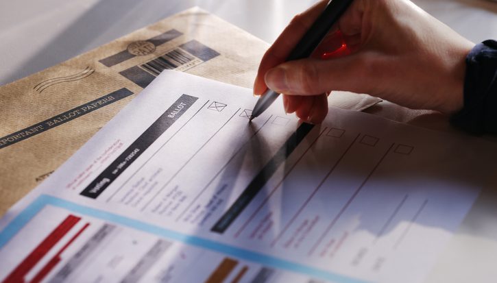 A woman’s hand filling in a postal ballot / voting form.