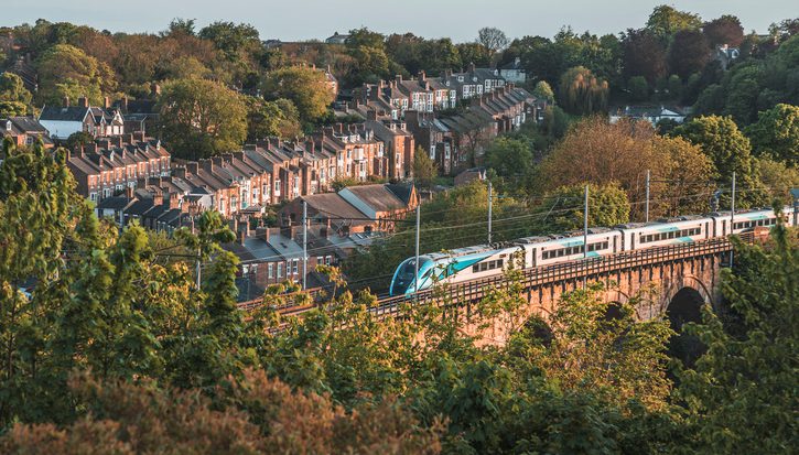 Townhouses beside the railway on the viaduct with a running train in Durham, UK