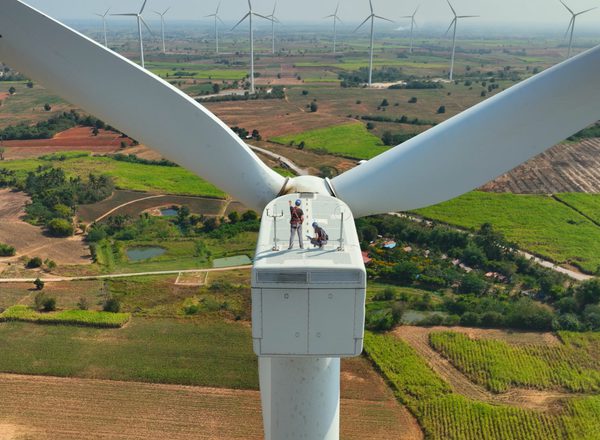 A view from above a wind turbine with two engineers standing on top of it