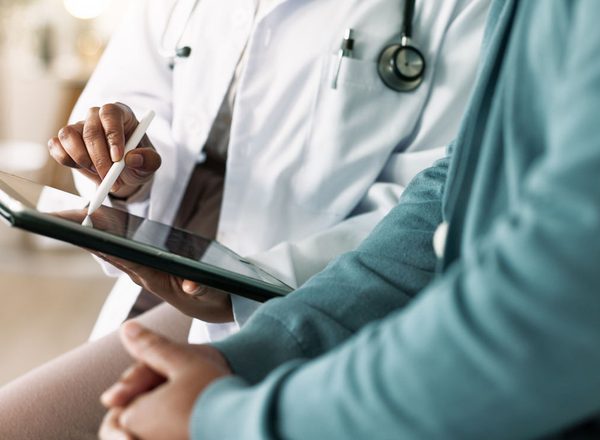 Doctor with patient for consultation, medical advice or procedure at clinic