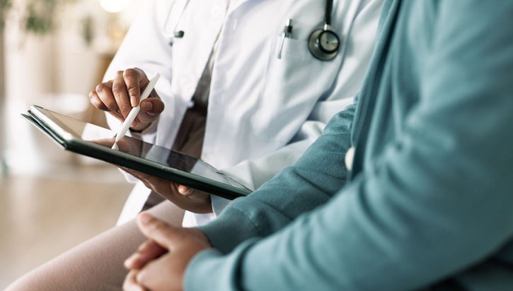 Doctor with patient for consultation, medical advice or procedure at clinic