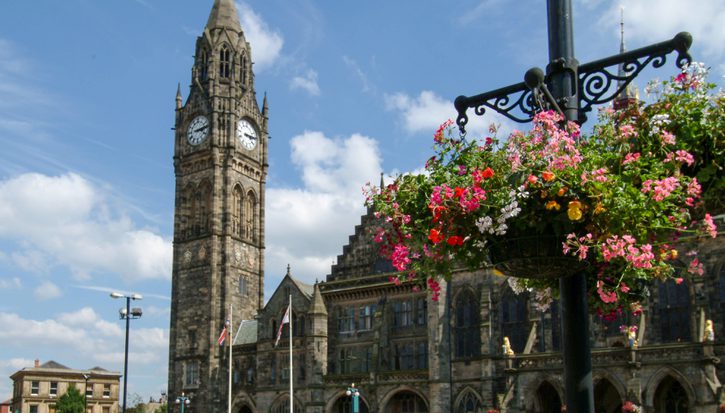 The outside of Rochdale town hall on a sunny day, with flowers in the foreground