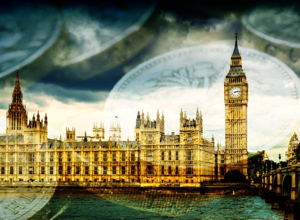 A photograph of the UK houses of parliament in Westminster, with a background of pound coins
